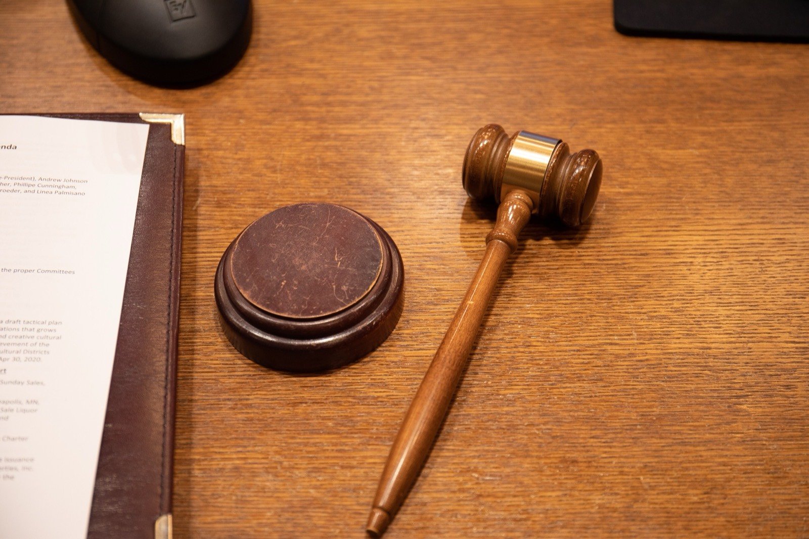 A judge's gavel and sounding block on a wooden desk